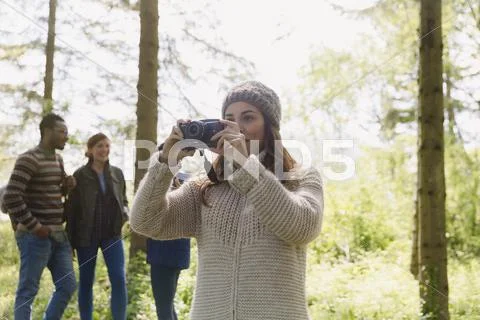 Woman using camera hiking in woods Stock Photos