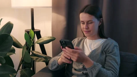 Woman using cell phone, looking on screen, typing online message on social media Stock Footage 202123077