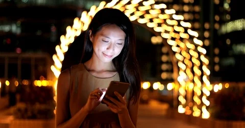 Woman using cellphone and walking at night Stock Footage