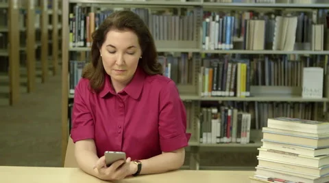 Woman using cellphone in library Stock-Footage 67365111