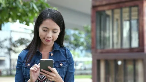 Woman using cellphone in the park Stock Footage 80208356