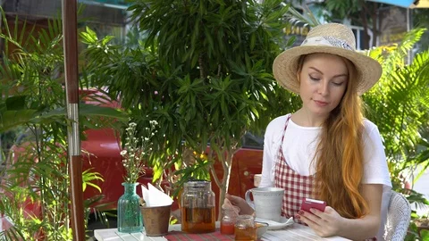 Woman using cellphone while drinking tea outdoors. Stock Footage 88667777