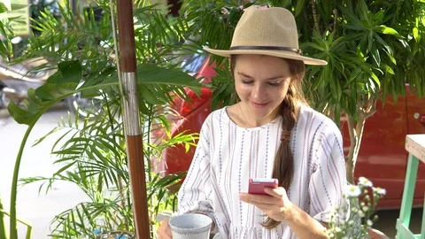 Woman using cellphone while drinking tea outdoors. Stock Footage 88668482