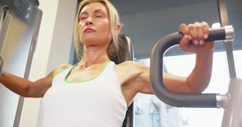 Woman Using Chest Press Machine in Gym 스톡 동영상 323772922