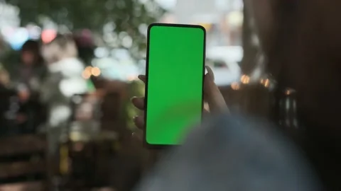 Woman using Chroma Key Smartphone while Sitting, Looking at the Green Screen Video stock 218069267