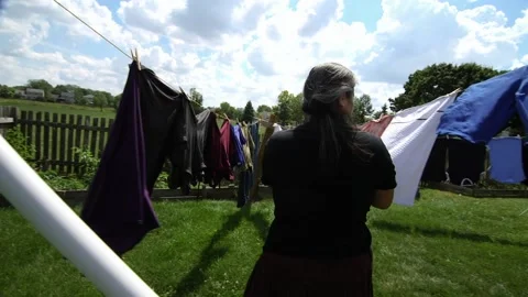 Woman Using Clothe Lines To Dry Clothes In an Energy Efficient Way Stock Footage 204867084