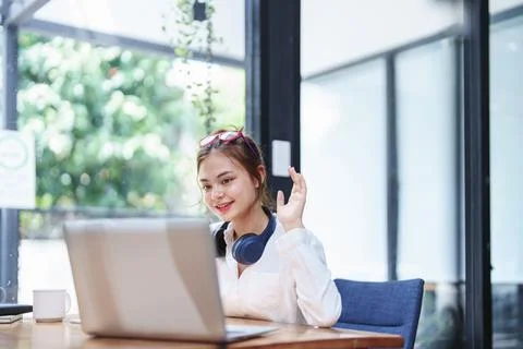 Woman using a computer and a notebook during a video conference Stock Photos
