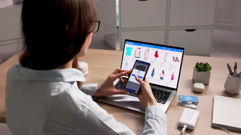 Woman Using Computer And Phone To Shop Online Stock Footage 334927547