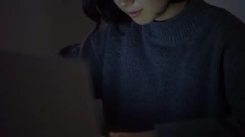 A woman using a computer in the dark Stock Footage 332578533