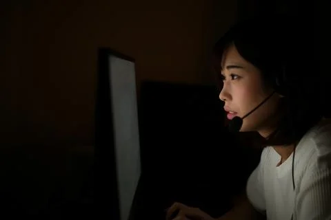 A woman using a computer in the dark Stock Photos