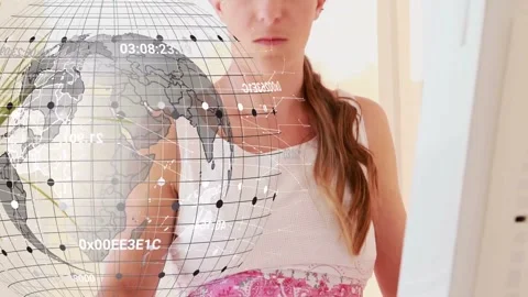 Woman using computer at desk, incoming call causing phone pickup, globe overlay Stock Footage 333396916