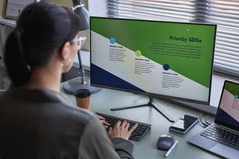 Woman using computer at desk working on development strategies Stock Photos