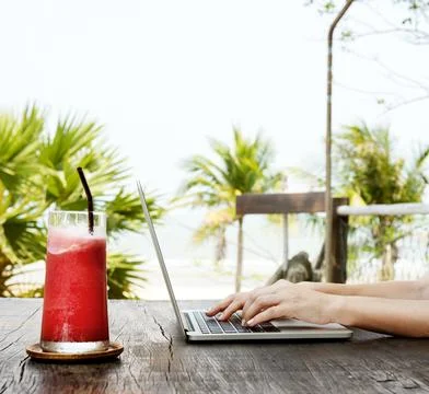 A woman is using computer laptop by the beach Stock Photos