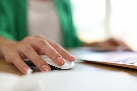 Woman using computer mouse working on modern laptop in office Stock Photos