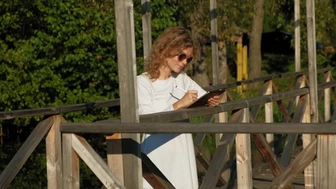 Woman is using a computer tablet outdoors. Video stock 116376386