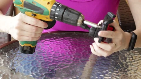 Woman using a cordless power screwdriver to remove a screw. Video stock 324247238