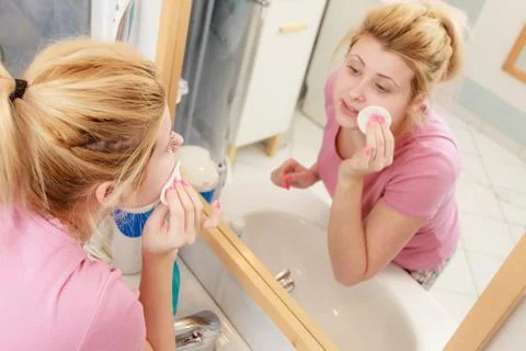 Woman using cotton pad to remove make up Stock Photos
