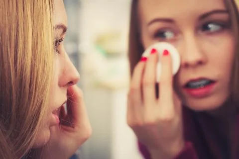 Woman using cotton pad to remove make up Stock Photos