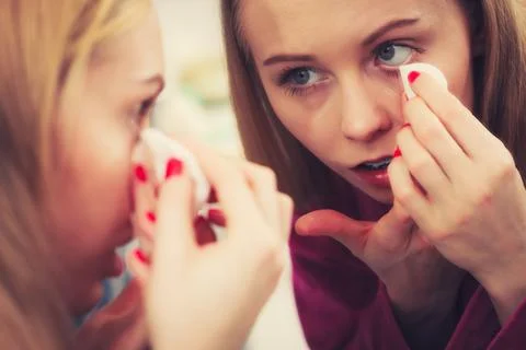 Woman using cotton pad to remove make up Stock Photos
