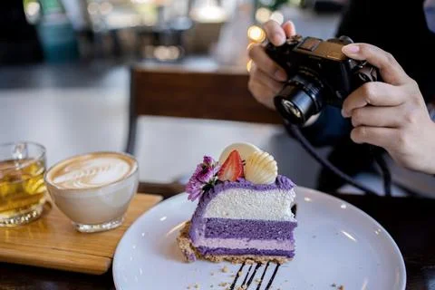 Woman using digital camera for take photo of cake and coffee in the cafe. Rel 库存照片