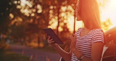 Woman using digital tablet by the car. Travel and technology. Slow motion. Stock-Footage 50956154
