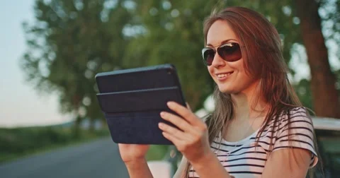 Woman using digital tablet by the car. Internet on a road. Travel technology. 스톡 동영상 50973050