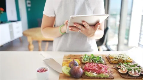 Woman using digital tablet to check recipe in kitchen Stock Footage 91171002