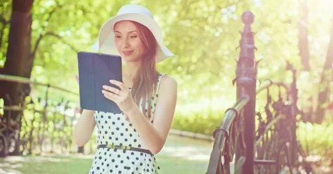 Woman using digital tablet in the green park outdoors. Beautiful young lady, Video stock 52763154