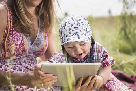 Woman using digital tablet with her little son in the countryside, Bavaria, Germ Stock Photos