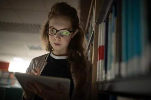 Woman using digital tablet in library room Stockfoto's