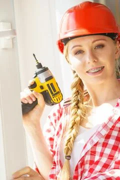 Woman using drill to fix or installing windows Stock Photos
