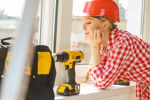 Woman using drill to fix or installing windows Stock Photos