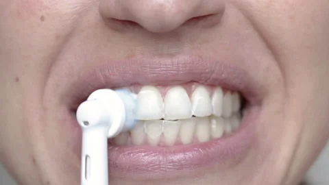 Woman using electric tooth brush for teeth daily cleaning routine Vidéo 210221973