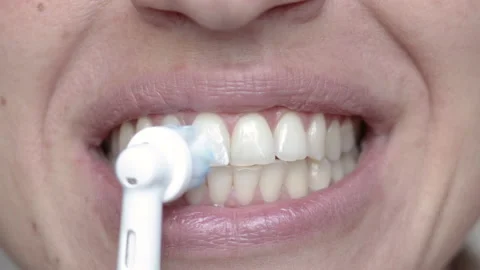 Woman using electric tooth brush for teeth daily cleaning routine Stock Footage 210222077