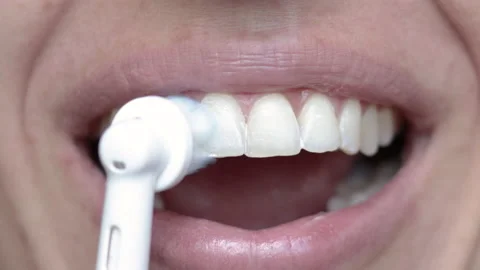 Woman using electric tooth brush for teeth daily cleaning routine 库存影片 210222174