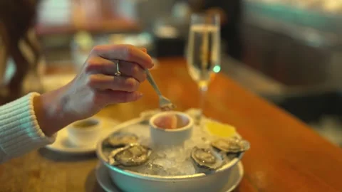 Woman Using Fork To Pick Seafood From Chilled Oyster Platter On Ice Stock Footage 337761832