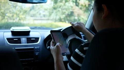 Woman using the Google Maps application on a smartphone while driving. Stock Footage 126195910
