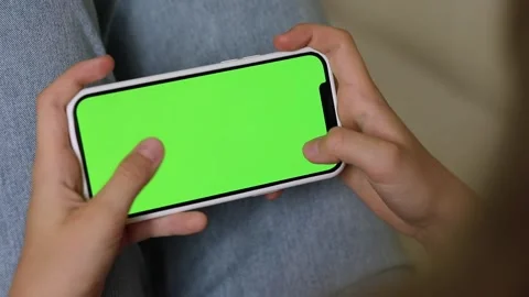 Woman using Green Mock-up Screen Smartphone in Horizontal Landscape Mode. Stock Footage 247736580