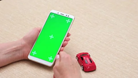 Woman using green screen chroma key phone in vertical position near red car Video stock 274214146