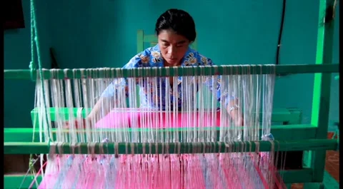 Woman using a hand weaving loom to elaborate traditional fabric Stock Footage 137430484