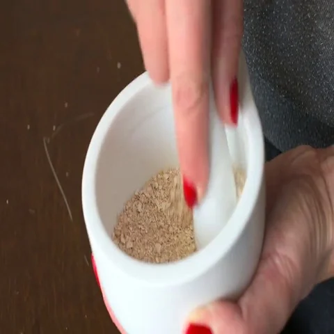 Woman using hands to pounding egg shells in stone mortar to dust   Stock Footage 69725327