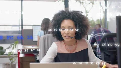 Woman using headset reaching, typing, speaking, helping caller in tech hub, code Stock Footage 333837794