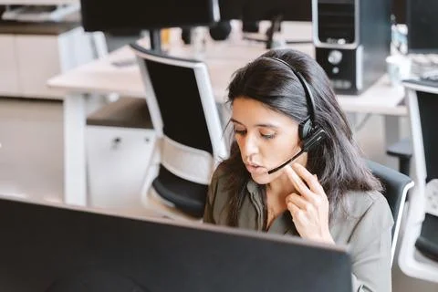 Woman using a headset while working in the office. Foto stock