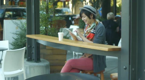 Woman Using Her Digital Tablet At Urban Cafe (with background activity) Video stock 35287989