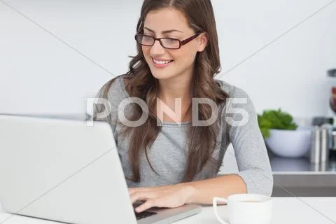 Woman using her laptop in the kitchen Stock-Fotos