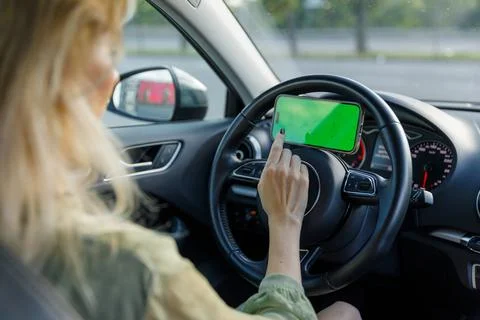 A Woman Using Her Smartphone While Driving: A Close-Up View of Modern Driving Stock-Fotos