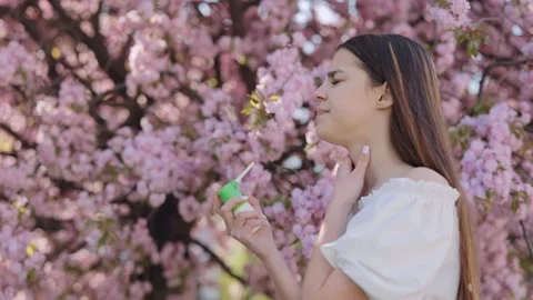Woman using inhaler during spring flowering outdoors Stock Footage 233164596