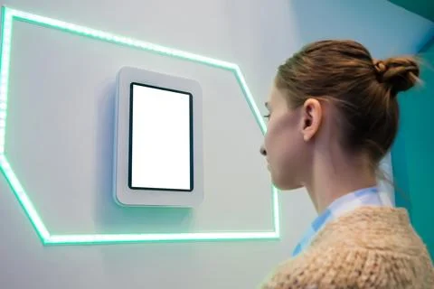 Woman using interactive empty white touchscreen display of tablet at exhibition Stock Photos