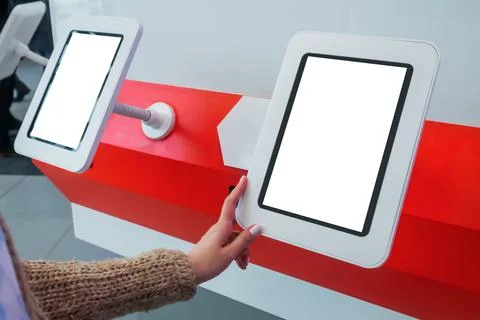 Woman using interactive empty white touchscreen display kiosk at exhibition Stock Photos