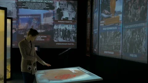 Woman using interactive touchscreen display at modern history museum Stock Footage 85245240